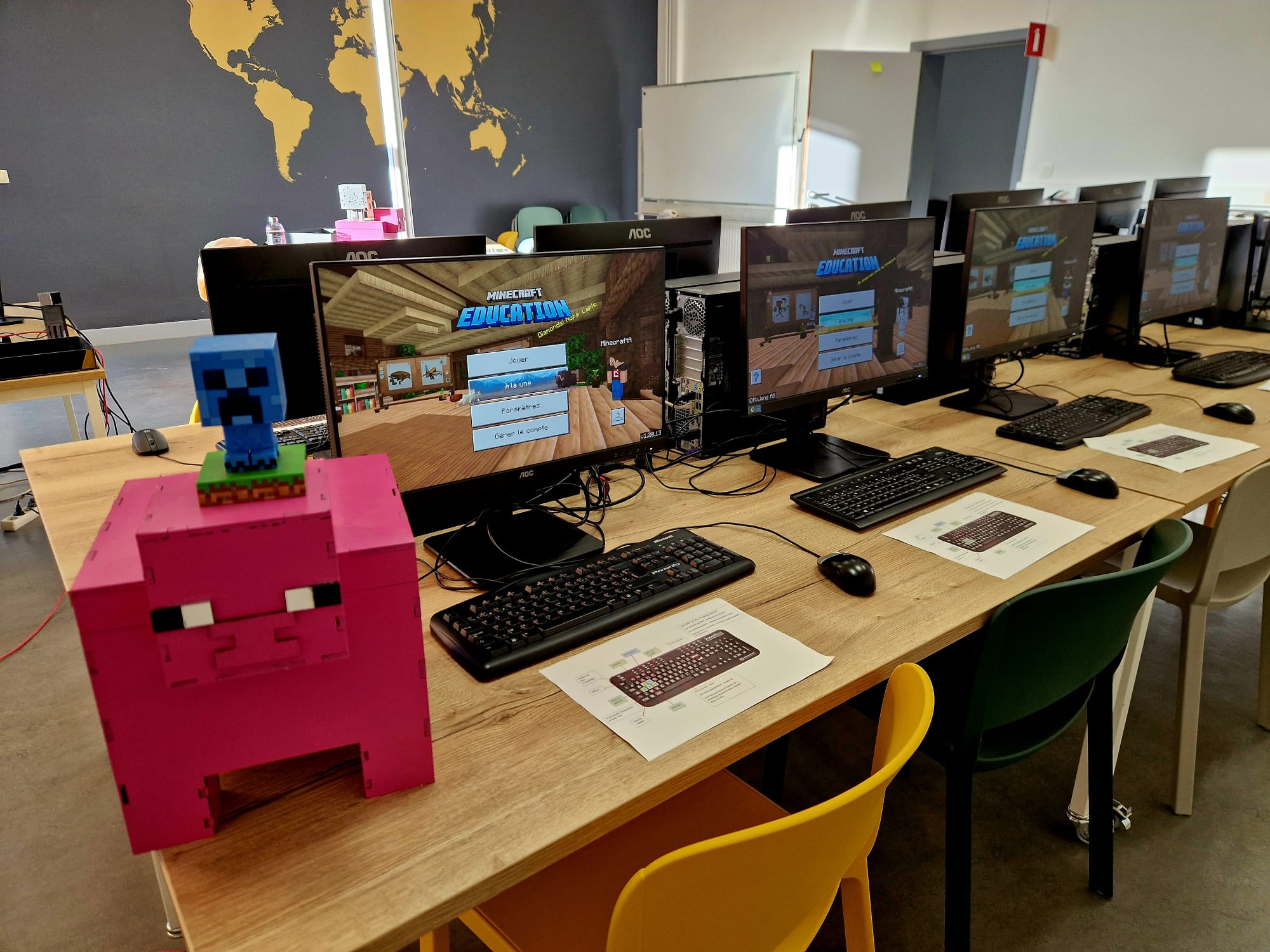 Postes équipés affichant Minecraft Education avec un cochon Minecraft en carton rose