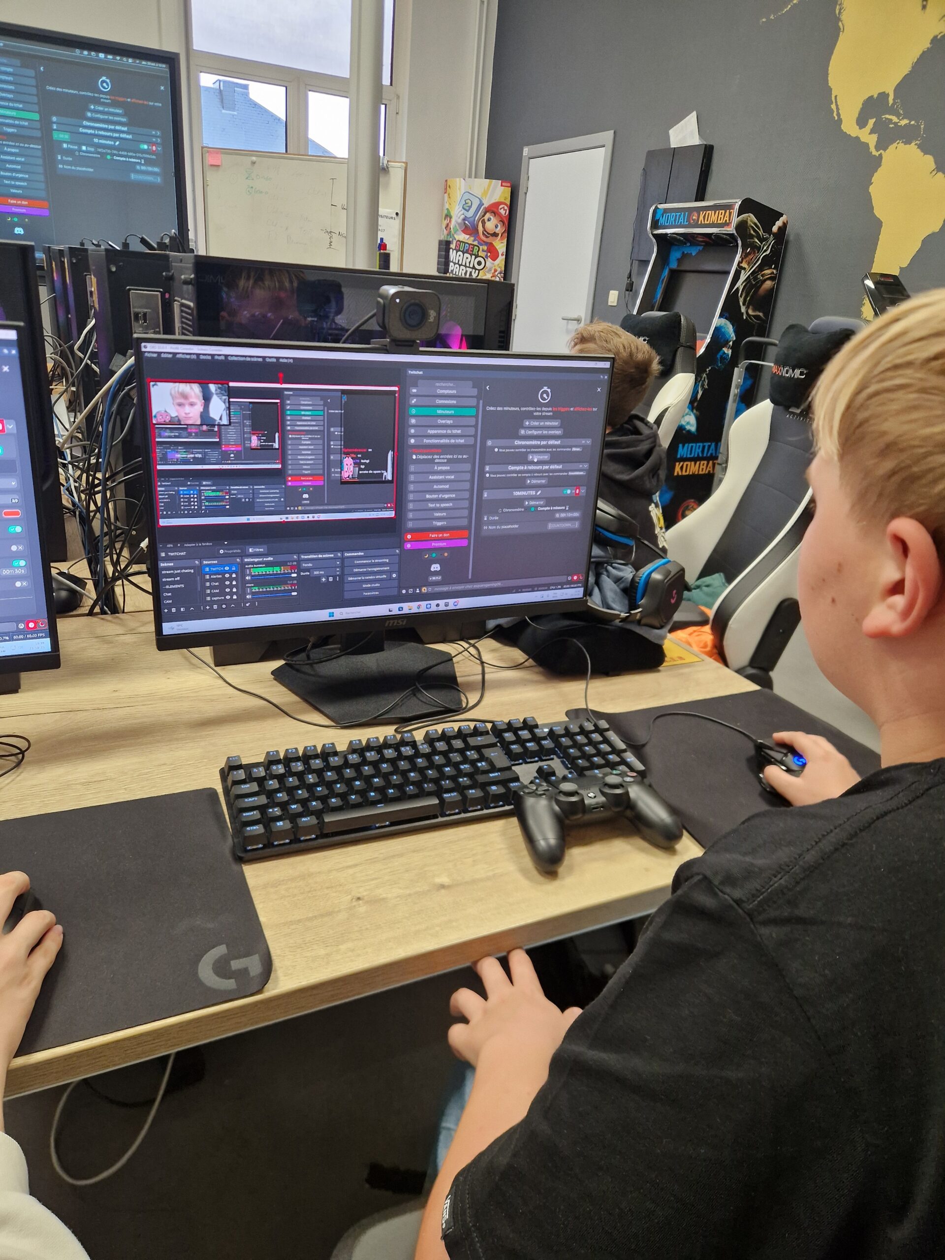 Joueur à un poste e-sport équipé d'une manette, d'un clavier mécanique et de sièges gaming