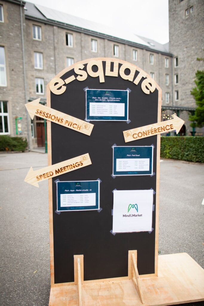 Panneau de signalétique en bois découpé au laser, indiquant les sessions pitch, la conférence et les speed meetings.